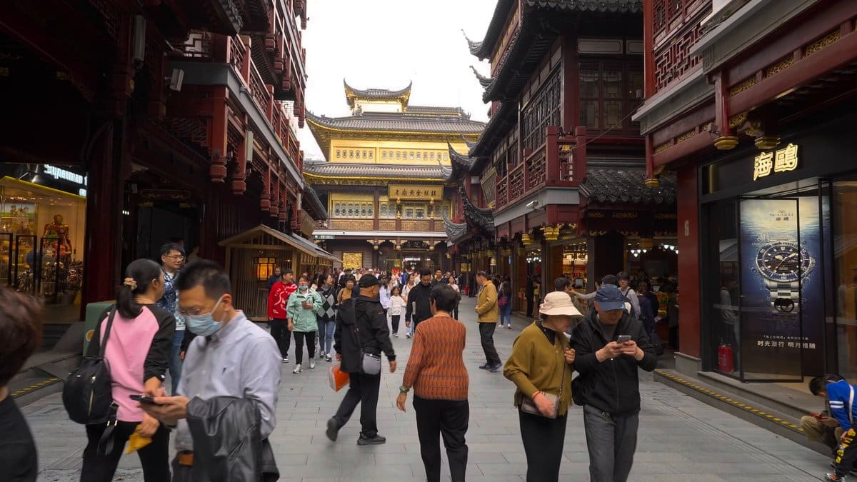 A bazaar lane lined with shopfronts, busy with
