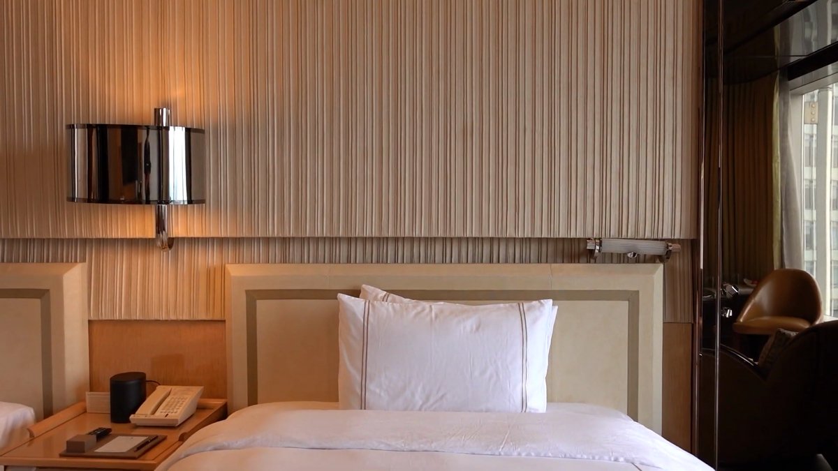 A bed against a striped fabric wall panel,