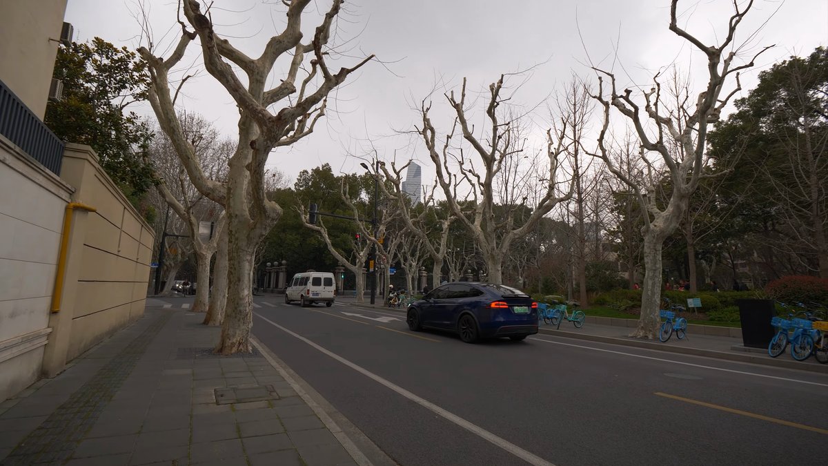 A broad street with a long boundary wall