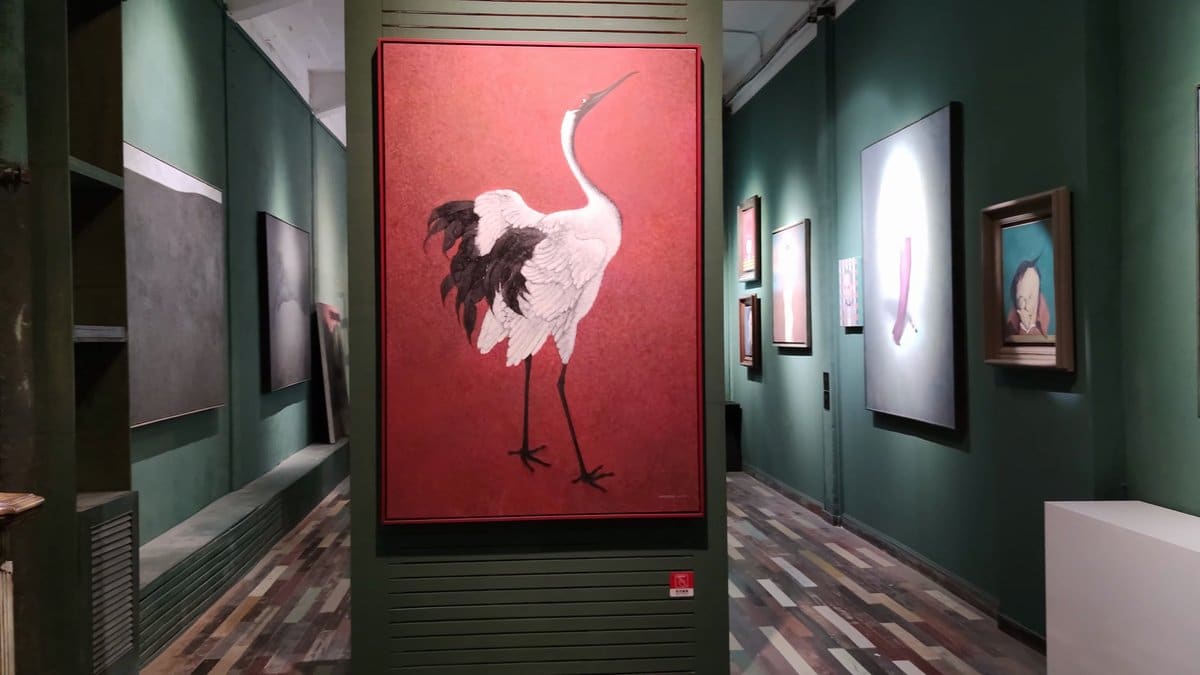 A dark green gallery room, a red panel