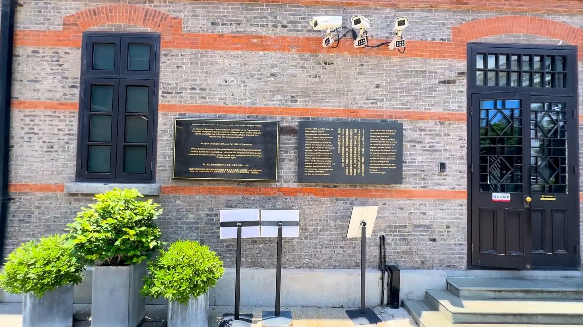 A dark rendered wall set with mounted plaques