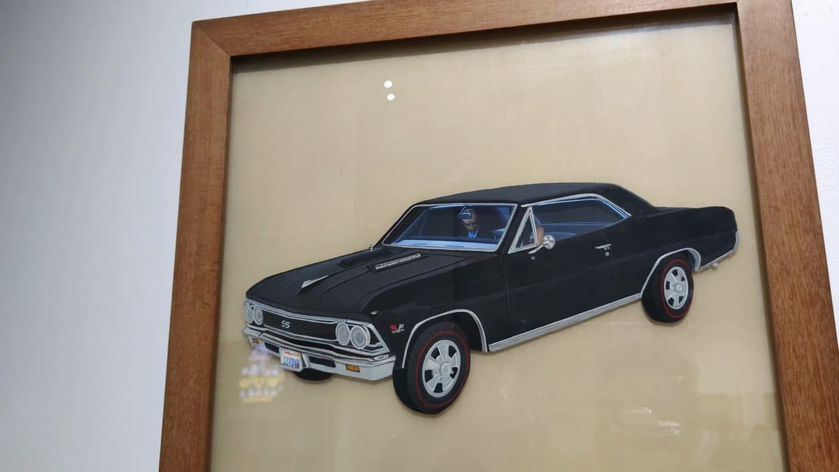 A framed relief of a black muscle car,