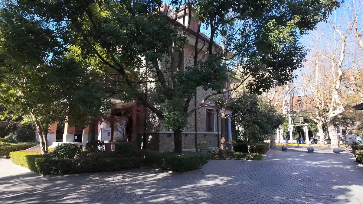 A lane running past a villa, trees and