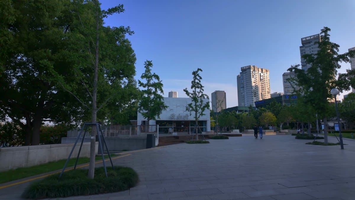 A paved area among the trees with apartment