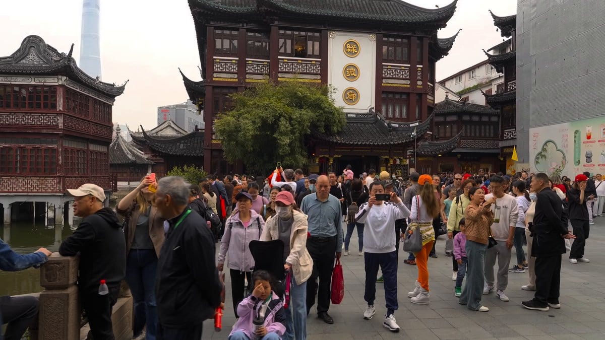 A plaza crowd beneath the tiered bazaar buildings,