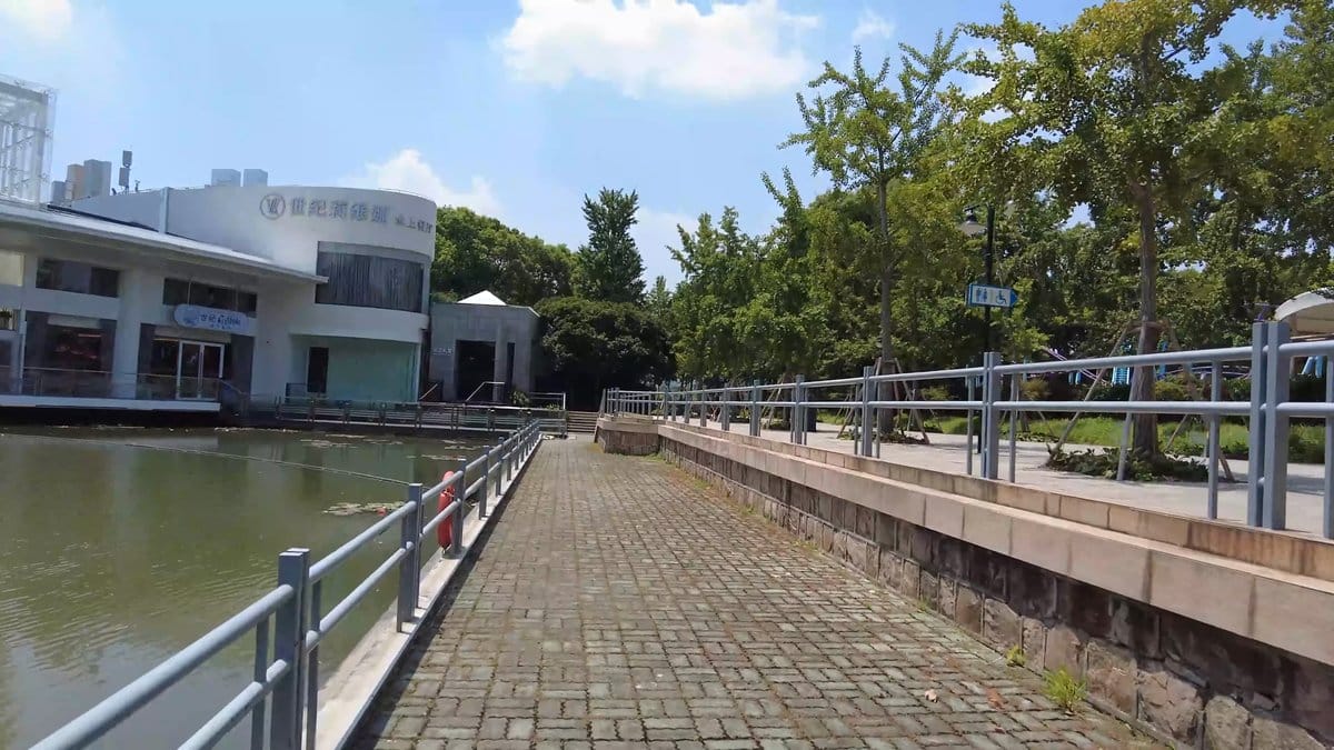 A raised walkway along the water with railings,