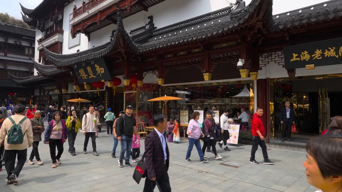 A shopfront row shaded by orange parasols beneath