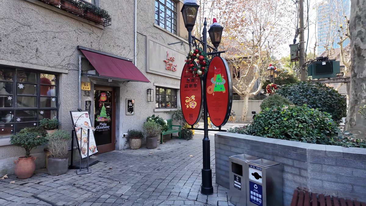 A shopfront under a red awning, a lamp