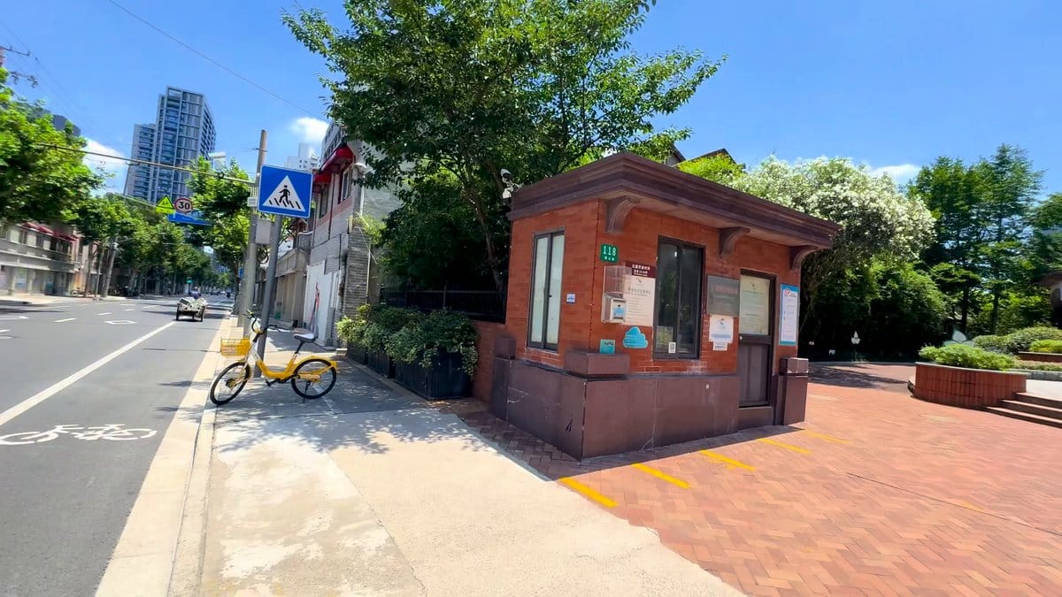 A street corner with a small brick kiosk,