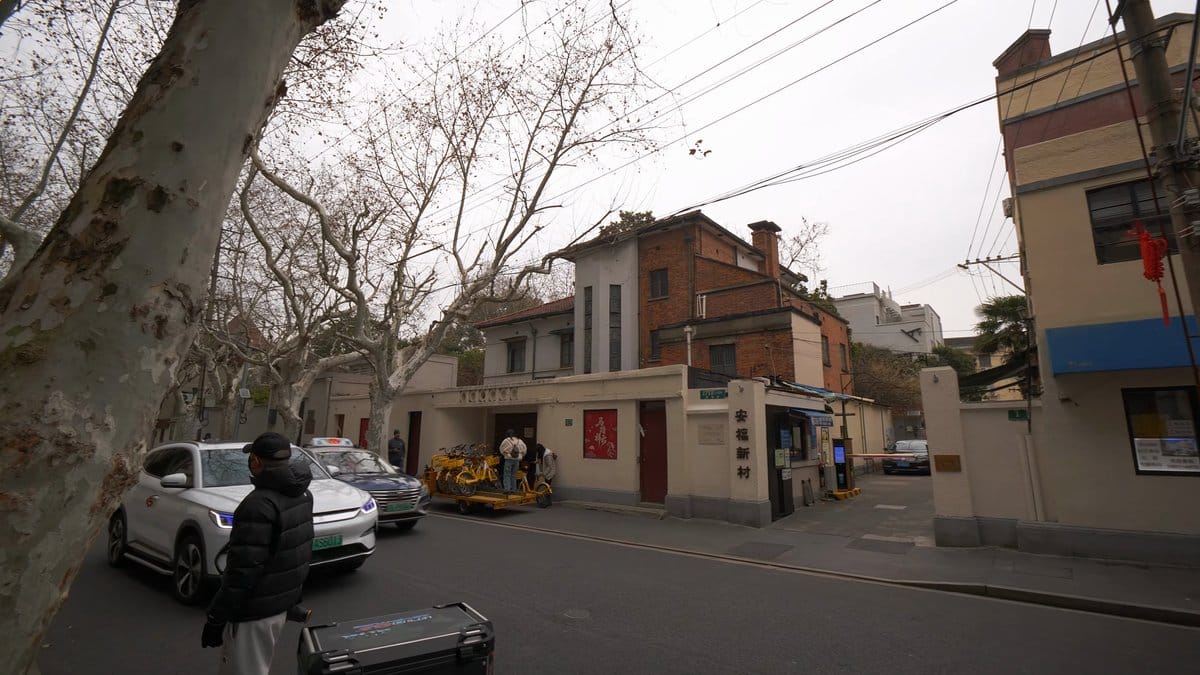 A street of parked cars with a scooter