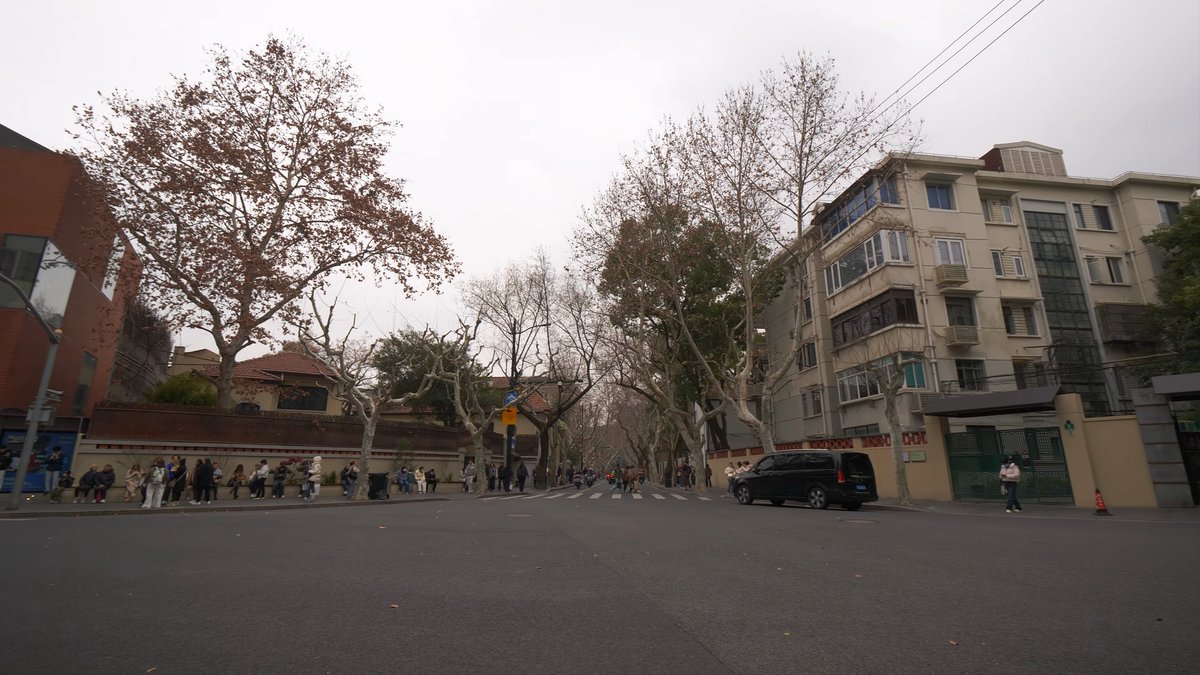 A wide street of modern residential blocks with