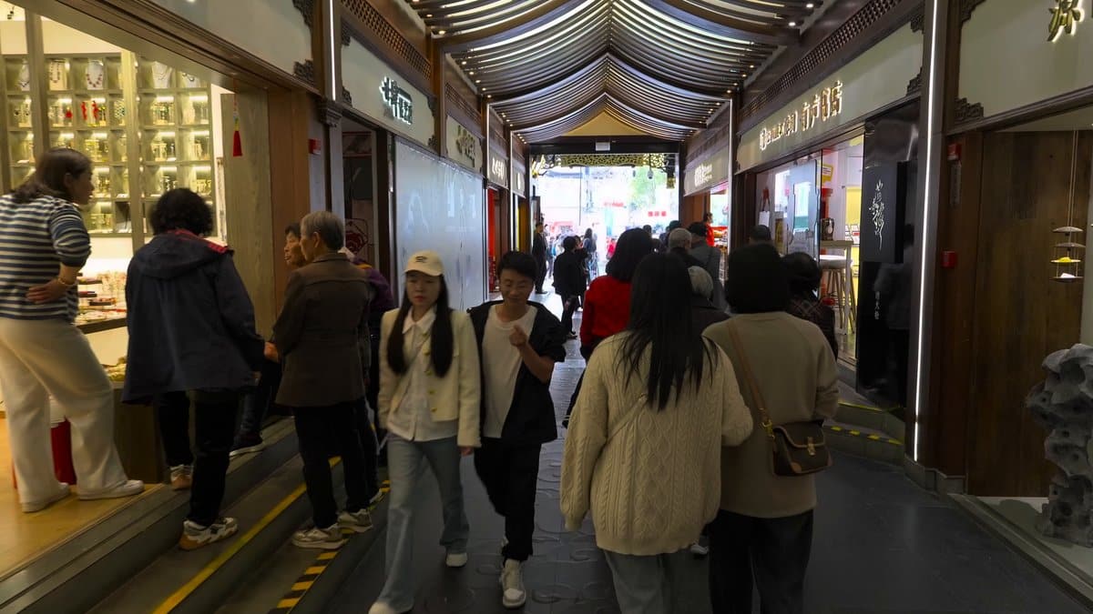 An arcade interior lined with shopfronts, visitors browsing