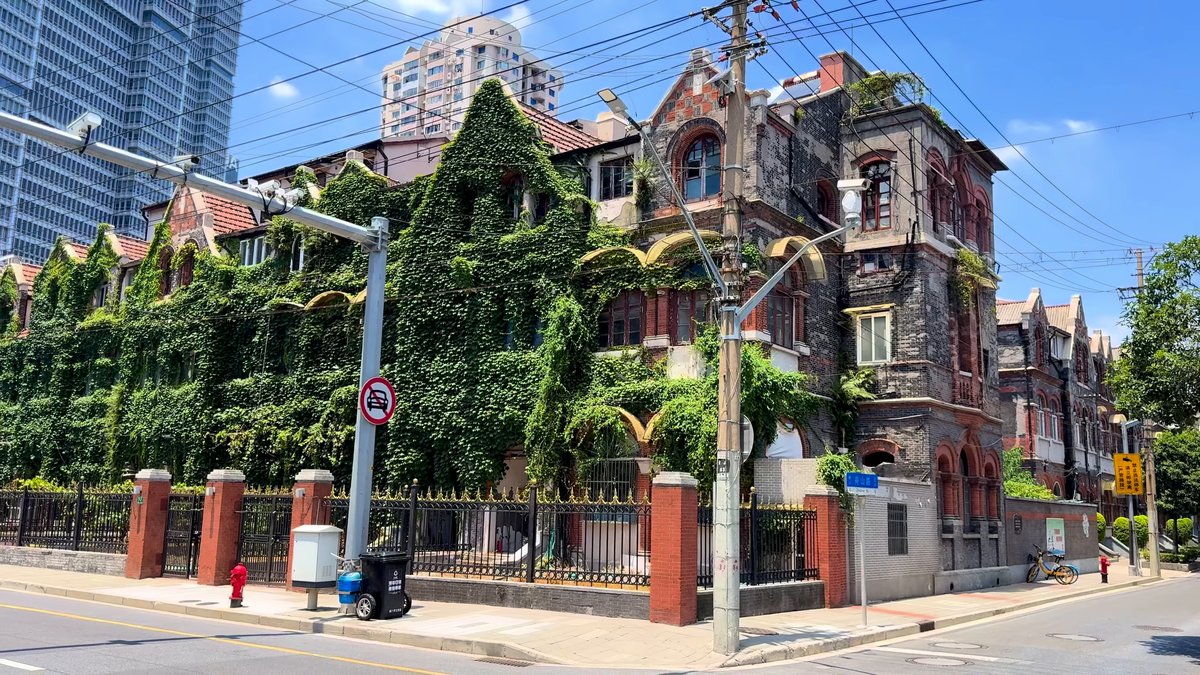 An ivy-covered mansion behind railings set on red