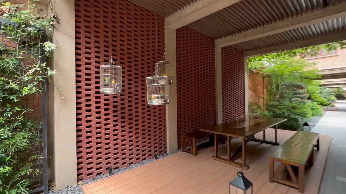 Birdcages hanging in brick passage