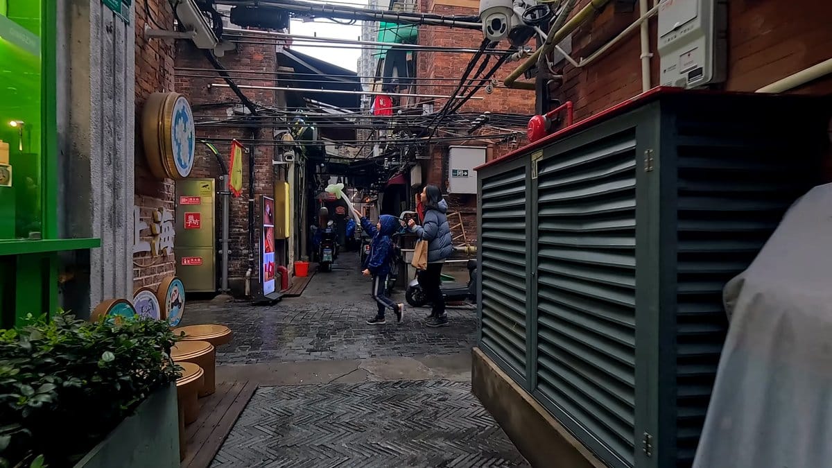 Brick walls closing the lane, visitors walking through