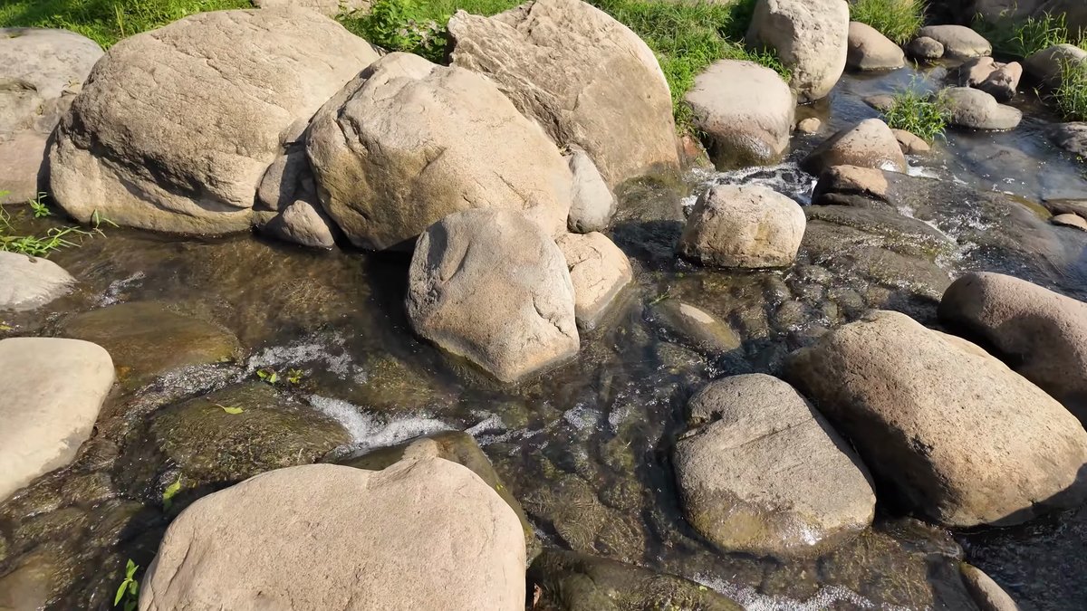 Clear water threading around smooth rocks