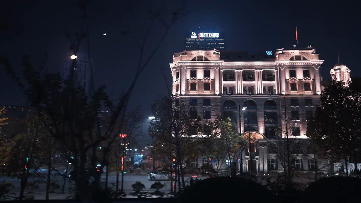 Floodlit classical building among trees