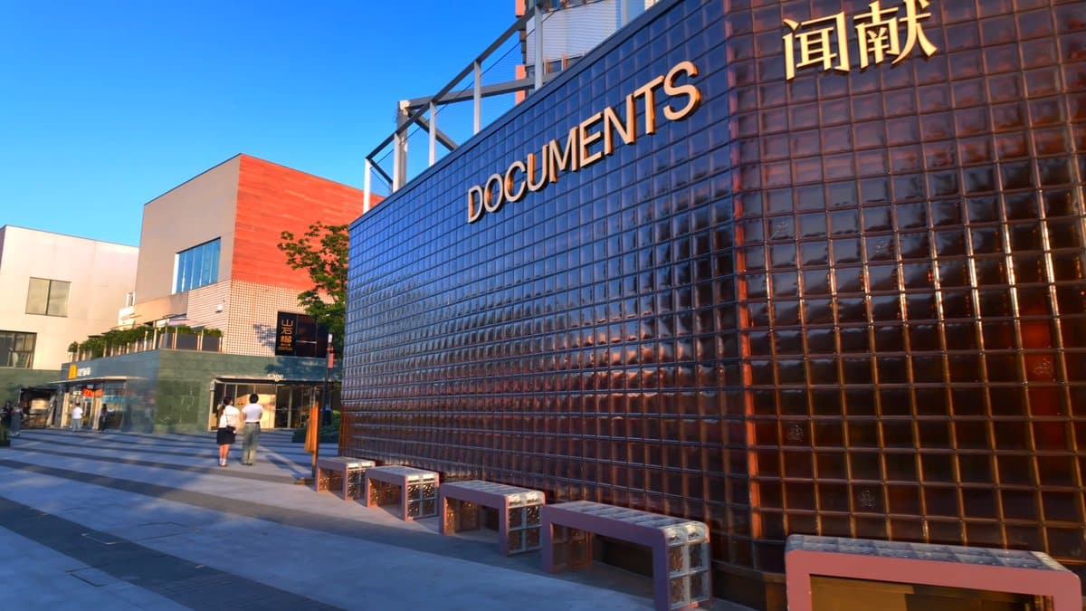 Lit glass-block Documents building at dusk