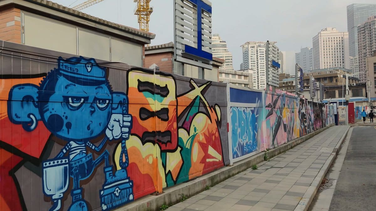 Long graffiti wall along the street