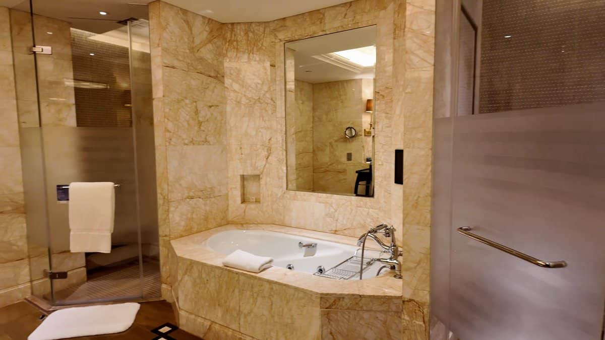 Marble bathtub below framed mirror