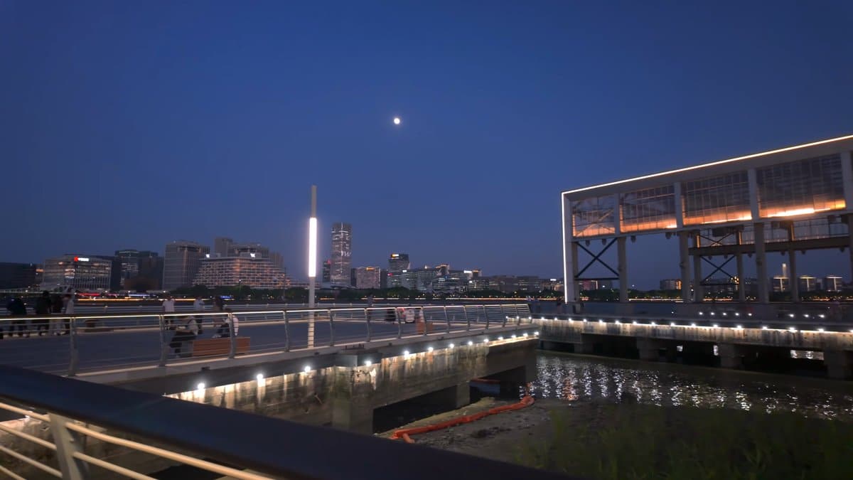 Moon over the lit riverfront