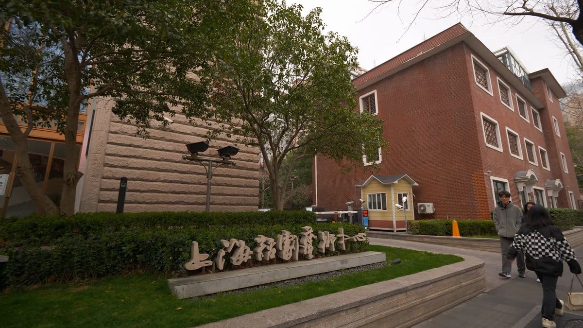 Red-brick buildings behind clipped hedge