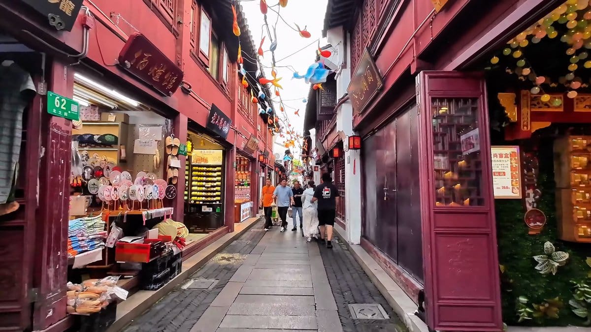 Red lanterns above overflowing shopfronts