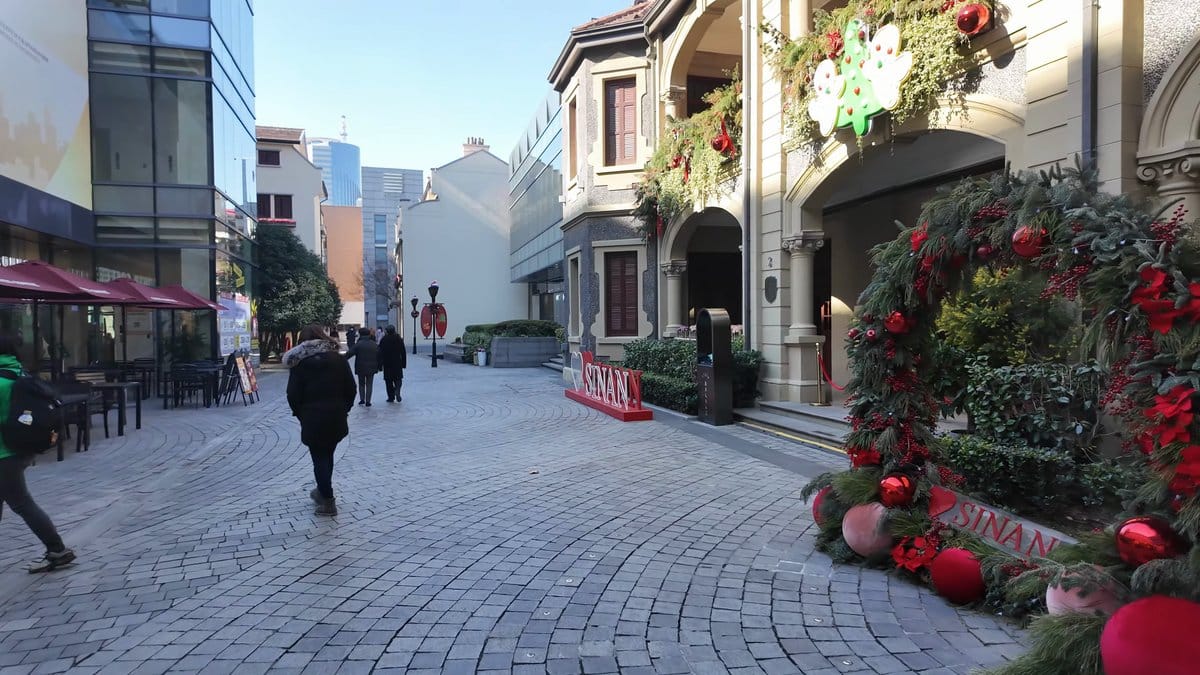 Red SINAN sign on paved lane