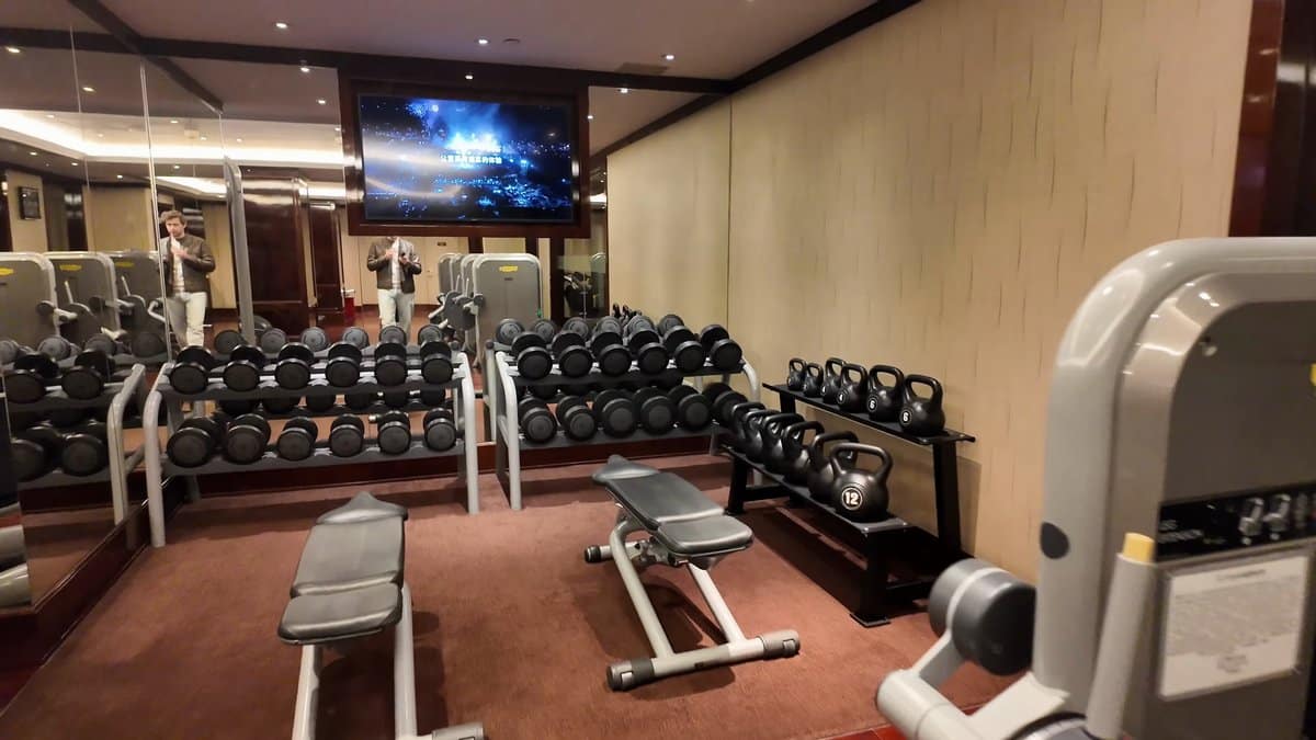 The dumbbell rack along the wall with the