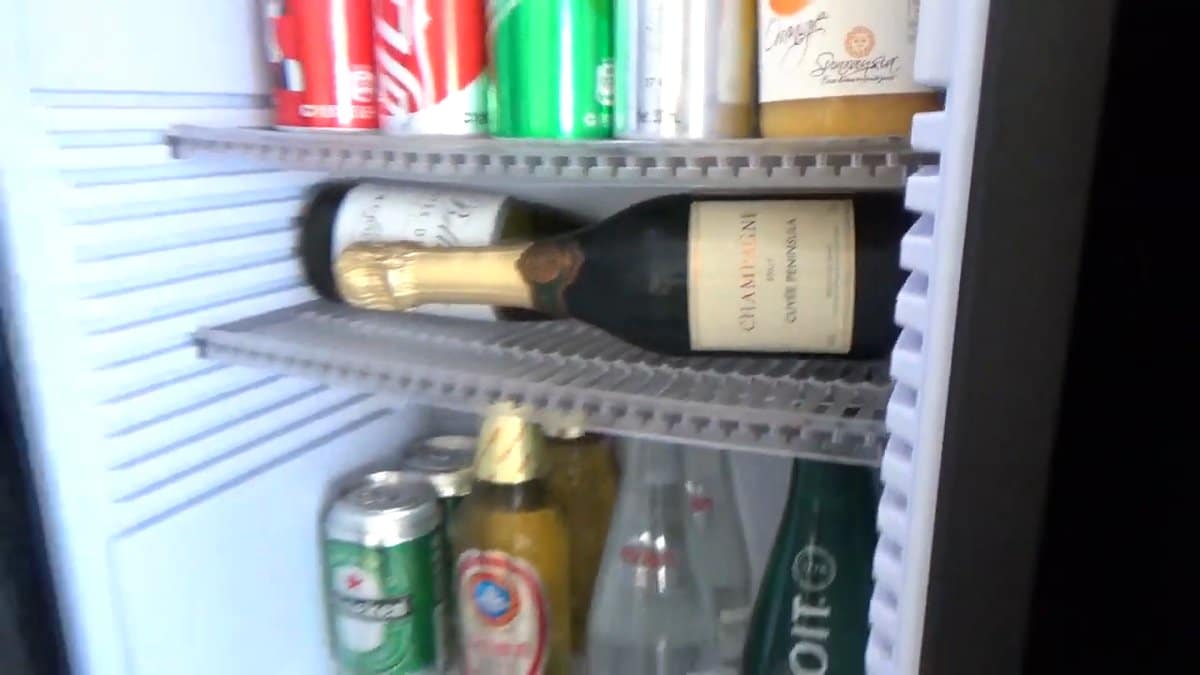 The minibar fridge open — the champagne lying