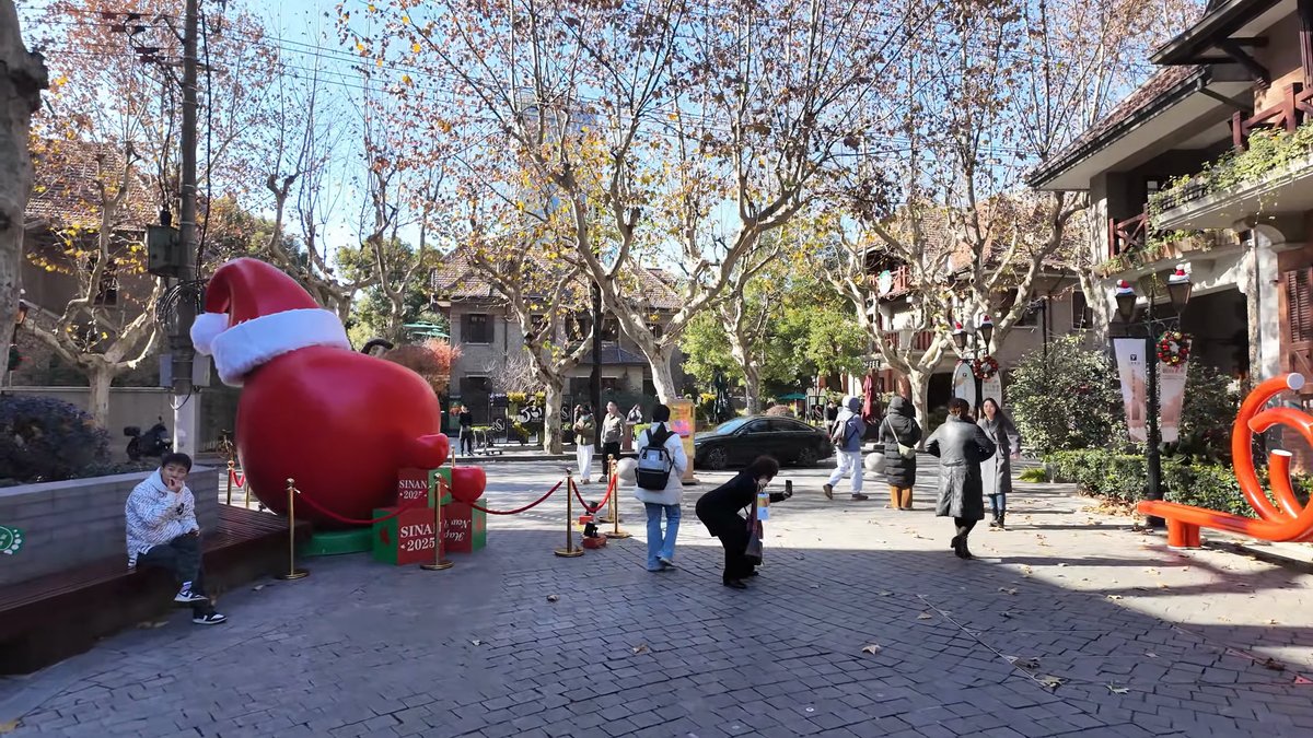 The plaza with the red apple sculpture, people