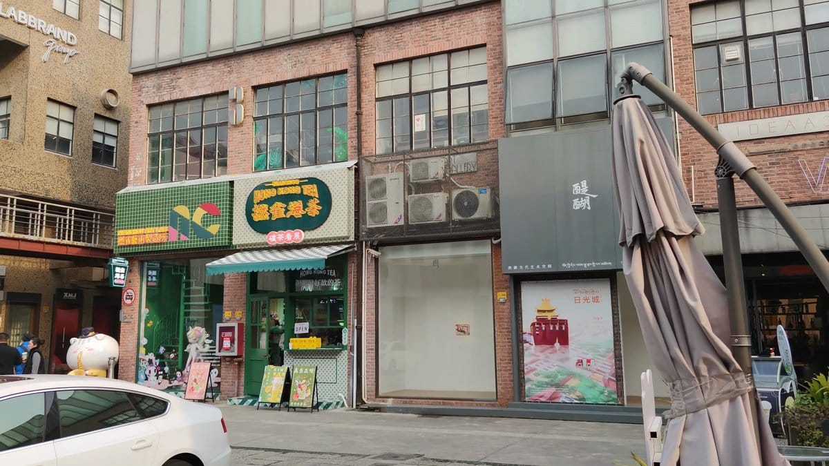 The street outside the gate, shopfronts under a