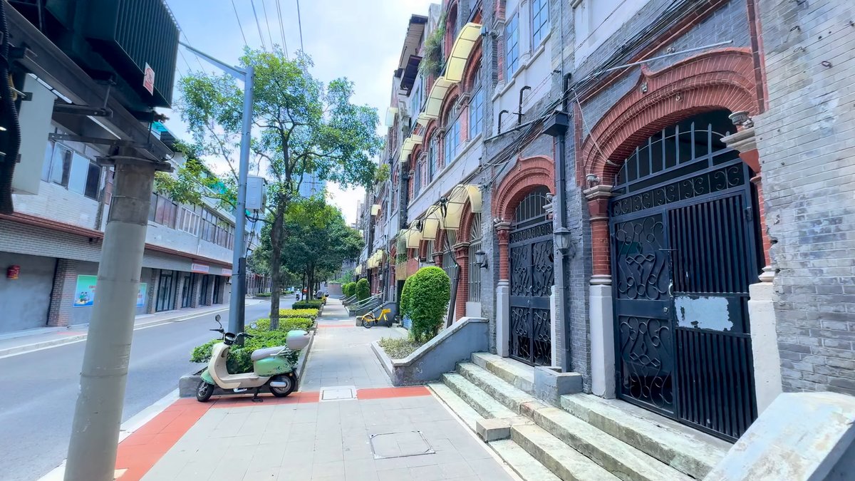 The street with a parked scooter, the brick