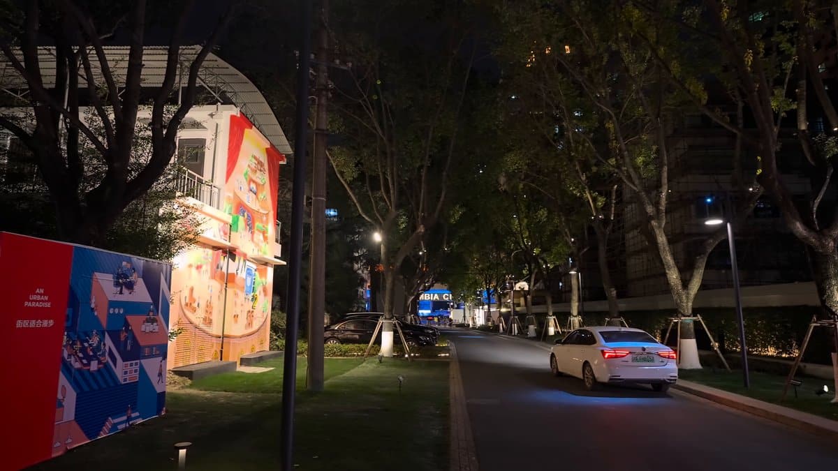 The street with printed hoardings along one side