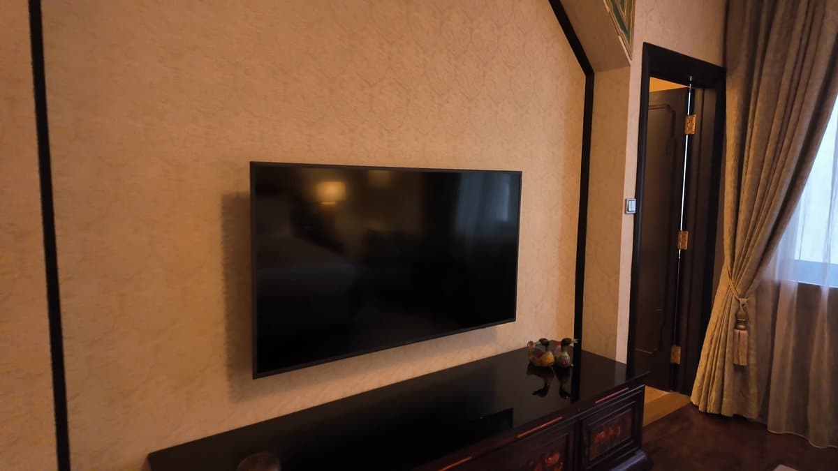 The television on the bedroom wall above a