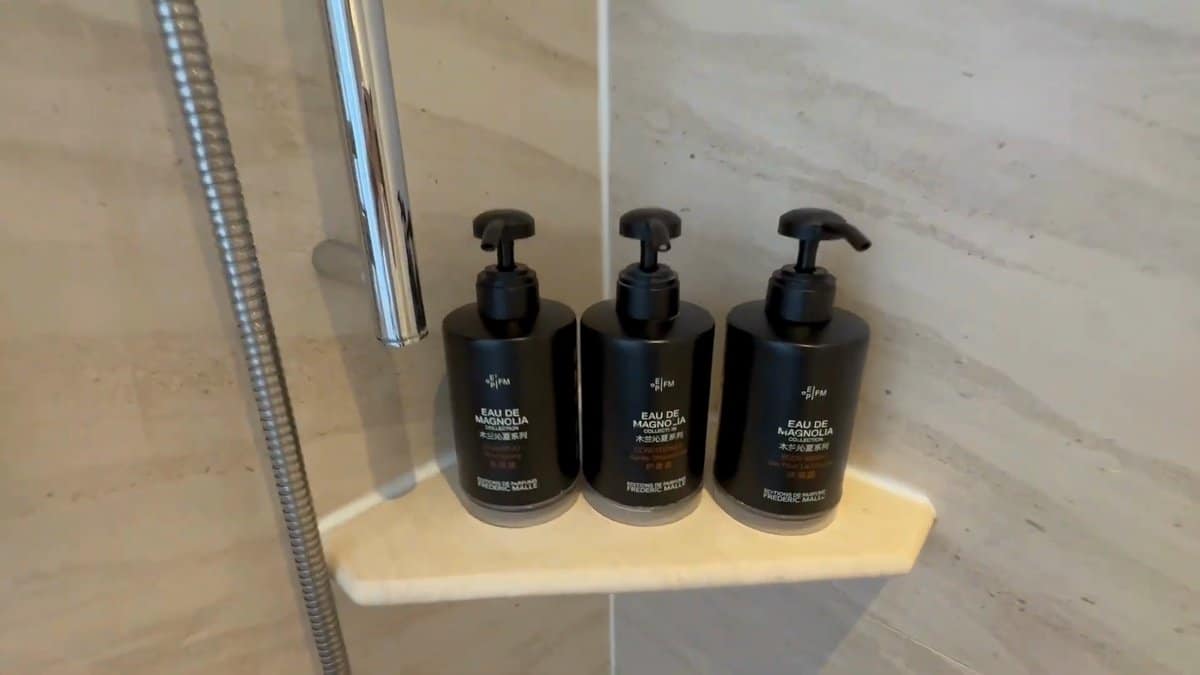 Three black pump bottles on the shower's stone