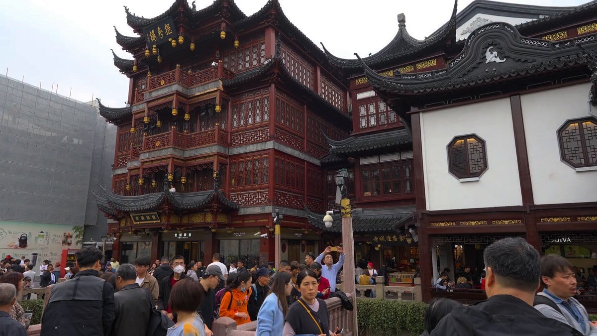Tiered traditional buildings above the crowds, construction sheeting