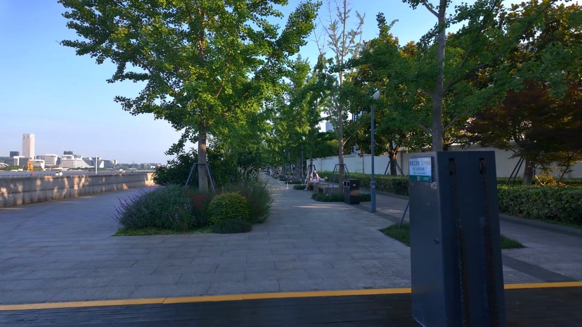 Tree-lined walk opening onto the river