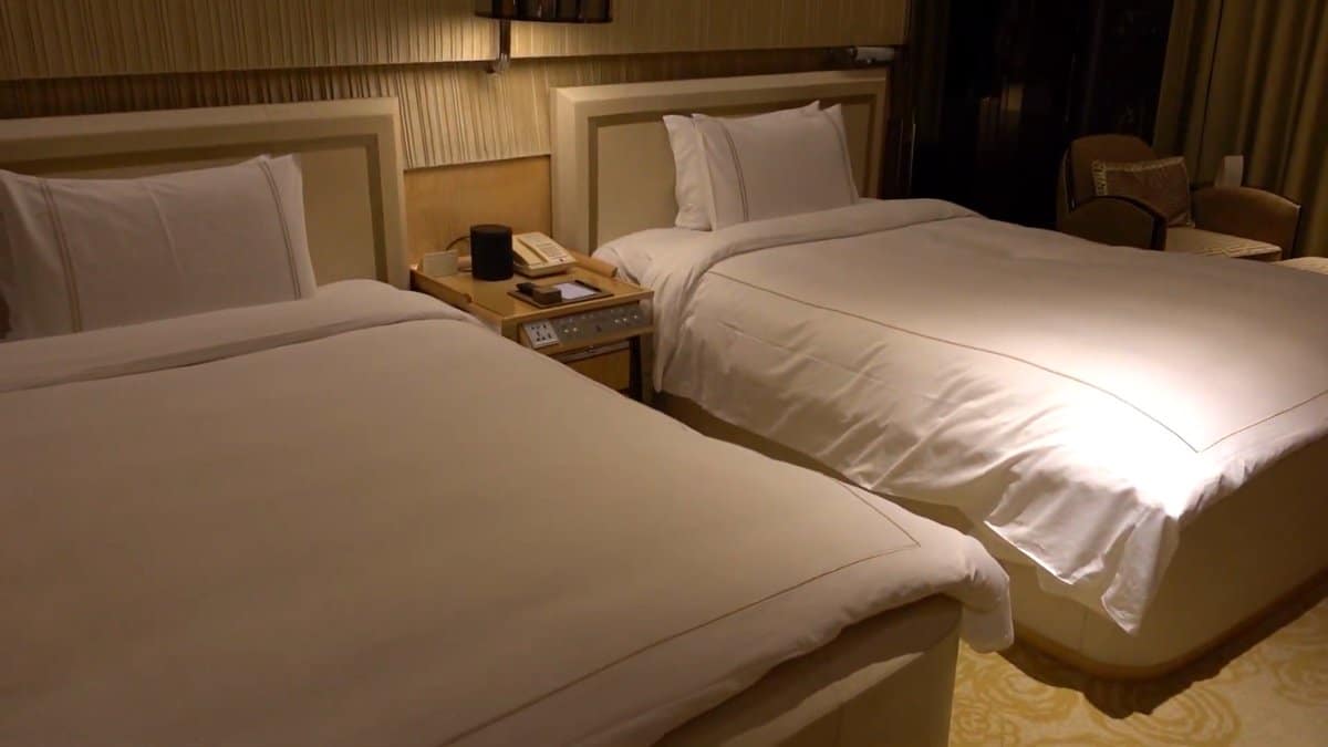 Twin beds against gold panelling
