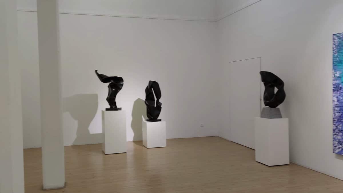 Twisting dark sculptures on plinths