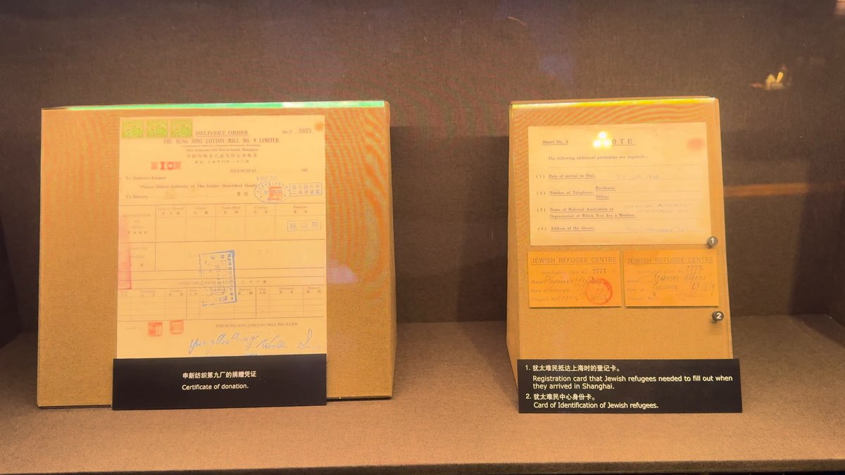 Two document facsimiles on lit stands — captions