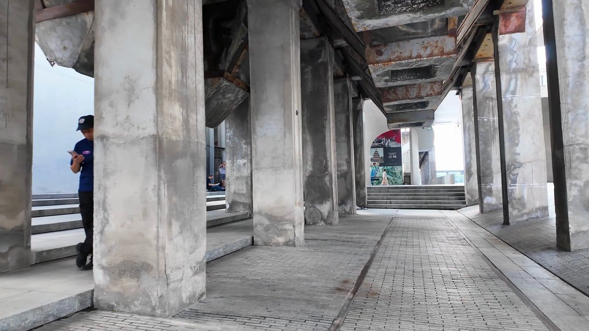 Visitor standing among concrete columns