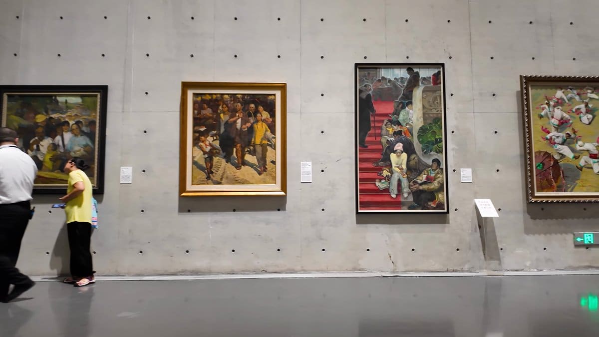 Visitors pausing before four paintings
