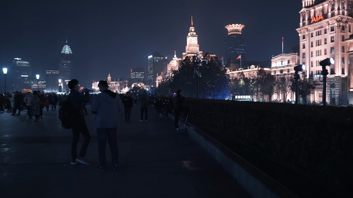 Walkers toward Bund towers and spires