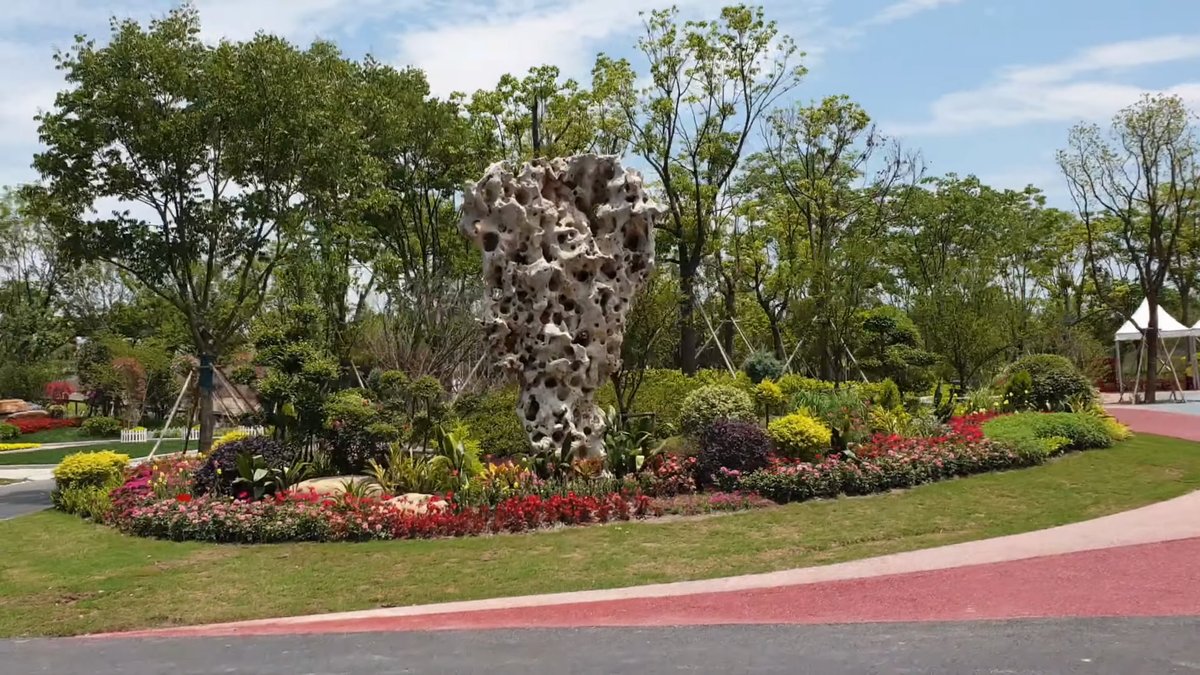 Weathered rockery stone among mixed shrubs