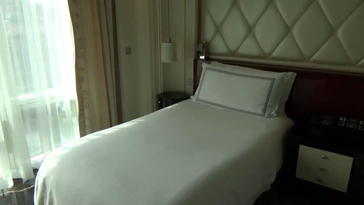 White bed quilted green headboard