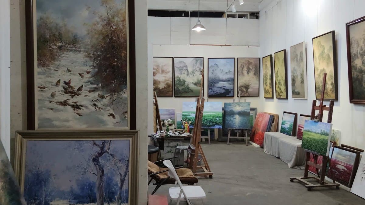 Working studio stacked with oil paintings