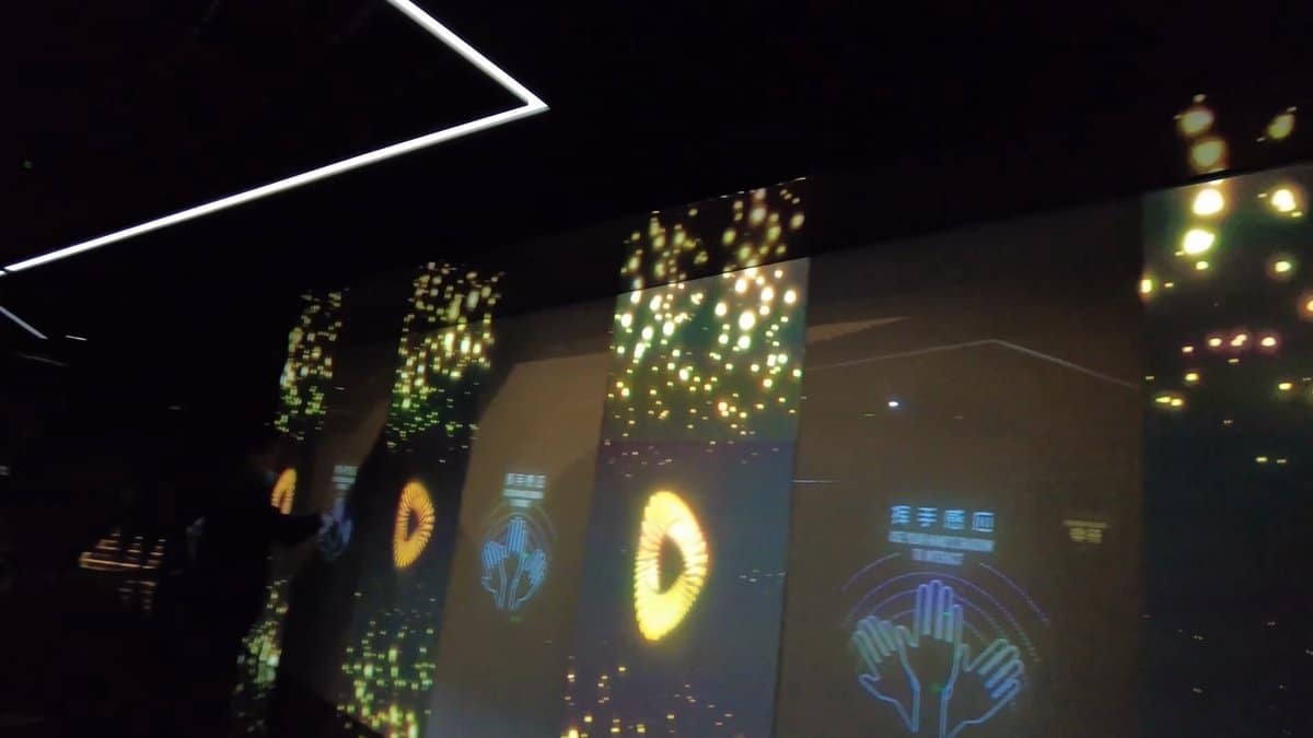 A darkened room of glowing projected panels, looped