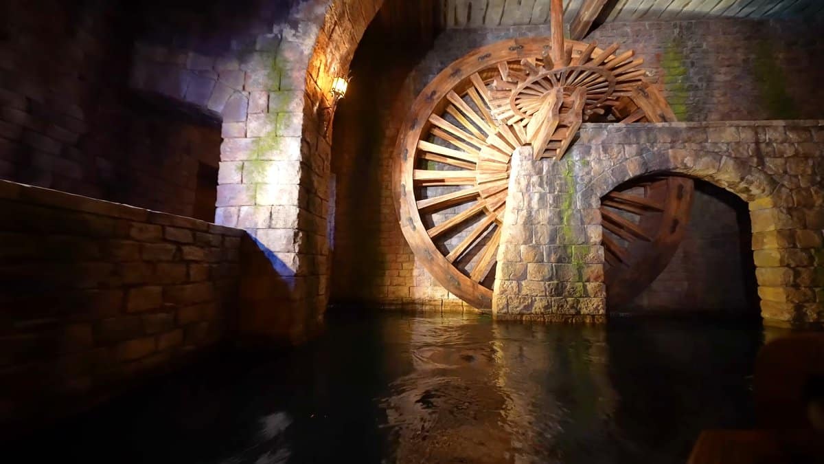 A flooded stone tunnel with a huge wooden
