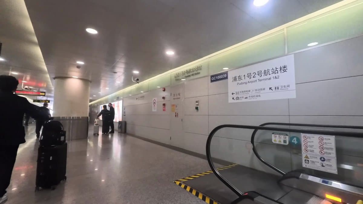 A moving walkway under a sign for 浦东1号2号航站楼,